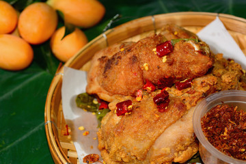 Fried chicken and roasted chili paste in a bamboo tray with bon leaf.