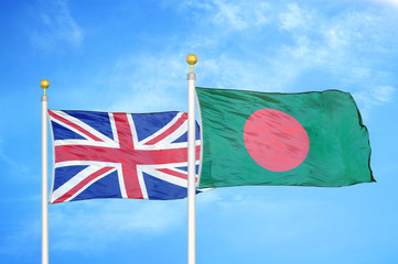 United Kingdom and Bangladesh two flags on flagpoles and blue cloudy sky