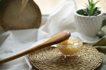 Preparing a sweet hot drink with ginger, lemon and honey for easing cold symptoms and feeling better  M