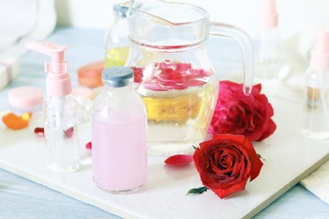 Fototapeta na wymiar Fresh roses, soap, petals, water and oil on the table for the preparation of natural cosmetics, spa, hygiene procedures, healthy lifestyle