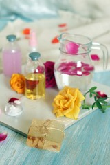 Obraz na płótnie Canvas Fresh roses, soap, petals, water and oil on the table for the preparation of natural cosmetics, spa, hygiene procedures, healthy lifestyle