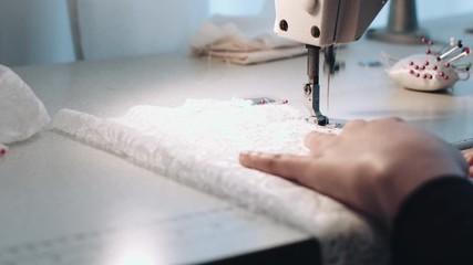 Young entrepreneur sewing wedding dress