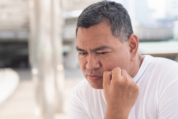 Fototapeta premium stressed senior old man thinking, planning; portrait of serious senior uncle thinking with stress for concept of idea finding, future retirement plan, recession or money problem in urban environment