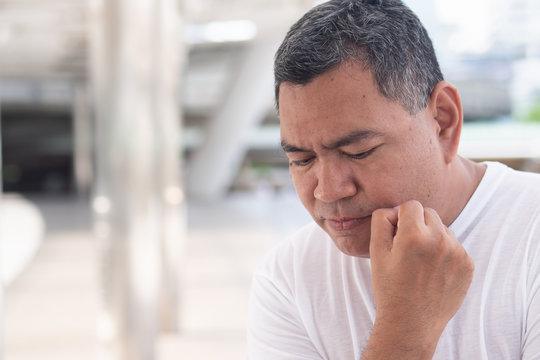 stressed senior old man thinking, planning; portrait of serious senior uncle thinking with stress for concept of idea finding, future retirement plan, recession or money problem in urban environment