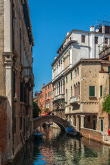 View of narrow Canal with boats and gondolas in Venice, Italy
