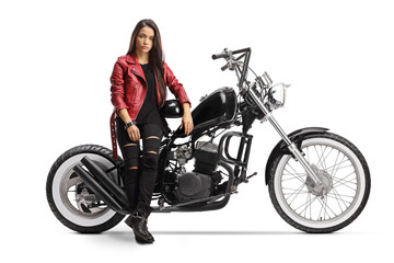 Obraz na płótnie Canvas Female biker holding a helmet and sitting on a chopper