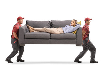 Movers carrying a sofa with a young woman lying