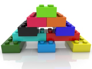 Fototapeta premium Colored toy bricks in the form of a pyramid on white