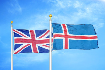 United Kingdom and Iceland two flags on flagpoles and blue cloudy sky