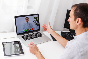 Fototapeta na wymiar Man Having Video Chat With Doctor On Laptop At Home