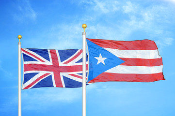 United Kingdom and Puerto Rico two flags on flagpoles and blue cloudy sky