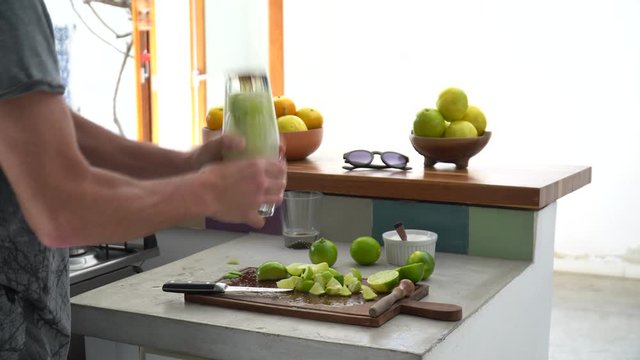 Close up of man hand preparing recipe for &ldquo;caipirinha&rdquo; drink with lime, sugar, ice and &ldquo;cachaca&rdquo; on kitchen countertop. The cacha&ccedil;a of Brazil is made of sugar cane. 4K