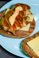 homemade hamburger with chicken, sauce and cheese fried on an electric grill