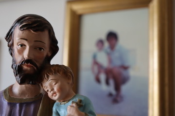 Festa del papà - Statuetta di san Giuseppe con Gesù e sullo sfondo una foto di un papà con la...