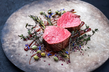 Gegrilltes dry aged Rinderfilet Medaillon Steak natur gebratenen Kräuter und Kapern als closeup...