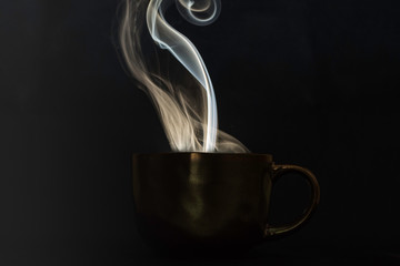 lighting up smoke over cup on black background