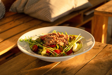 Restaurant serving food. Tuna salad in a plate on a table in a summer cafe