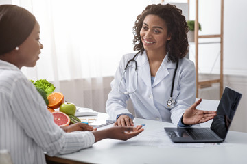 Smiling female doctor nutritionist having conversation with her patient