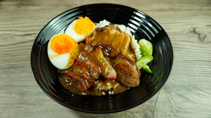 Barbecued red pork and crispy pork in sauce with rice or thai name Kao Moo Dang. Street food menu in Thailand