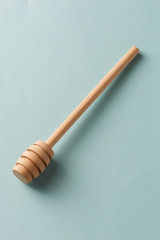 Wooden honey spoon on blue background