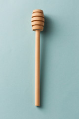 Wooden honey spoon on blue background