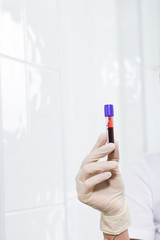 Covid-19, coronavirus, pandemic and viruses concept - woman holding blood in tests tubes close up.