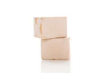 Obraz premium Two yeast cubes for bread making isolated on white background.