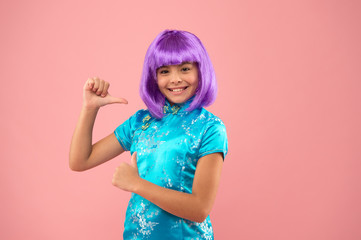 asian girl pointing finger. small chinese girl in purple wig. happy kid in traditional Chinese gown. chinese new year. stylish child in kimono. child wear national robe. festival day in Japan