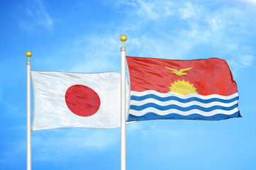 Japan and Kiribati two flags on flagpoles and blue cloudy sky