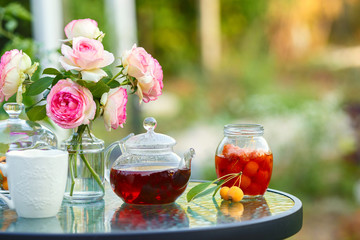 Tea in glass teapot. Romantic lunch in the garden. Summer time. Close up. Free space for text.