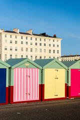Naklejka premium Hove beach huts against the backdrop of Regency buildings that line the seafront.
