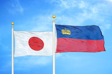 Japan and Liechtenstein two flags on flagpoles and blue cloudy sky
