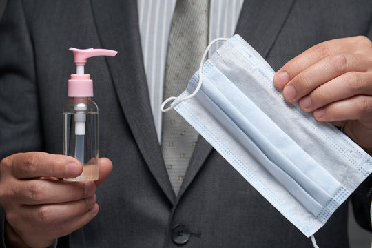 a man demonstrates a protective face mask for antivirus individual protection and bottle of sanitizer liquid- healthcare and medicine concept, prevention tips