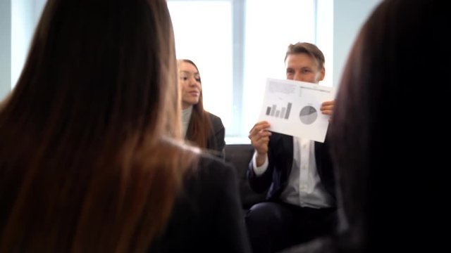 Manager conducts a financial report, shows growing statistics and growing schedules to colleagues