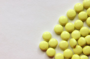 Yellow tablets on a white background close-up . The tablets are located on the right side. Copy space