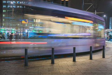Close up fast blurred trail of train in traffic motion in illuminated metro, Netherlands.
