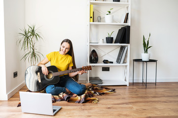 A woman watches video tutorial on guitar playing