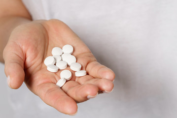 Female hand with a handful of pills