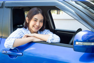 Asian women driving a car and smile happily with glad positive expression during the drive to travel journey, People enjoy laughing transport and drive thru concept