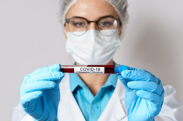 Female doctor is holding a blood sample of the COVID-19