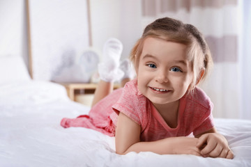 Cute little girl on bed at home