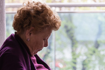 Elderly woman sitting by the window