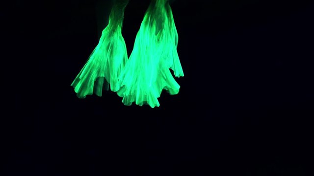 UV neon ink in water on black background. Slow motion video.