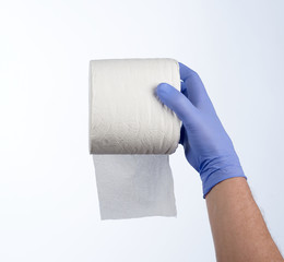 Right hand in blue glove holding a roll of toilet paper