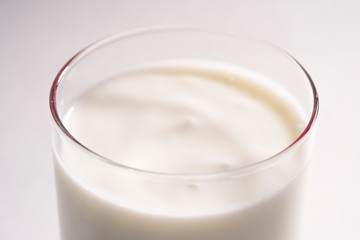Glass of fresh vegetarian yogurt on coconut milk. Eco milk in a transparent glass on a white background, isolated