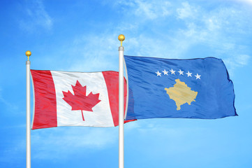 Canada and Kosovo two flags on flagpoles and blue cloudy sky