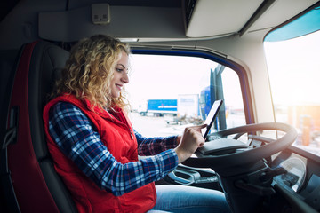 Truck driver setting up navigation GPS equipment to get directions for destination.