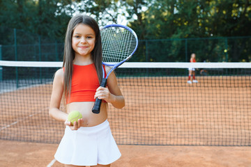 Cute little girl playing badminton outdoors on warm and sunny summer day