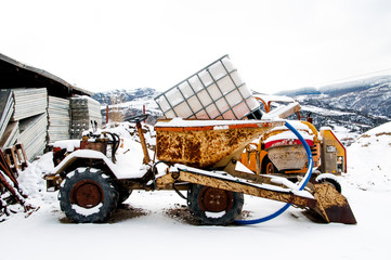 Old tractor with load, full of snow, in small town, agriculture of Castelmezzano, Italy, Europe