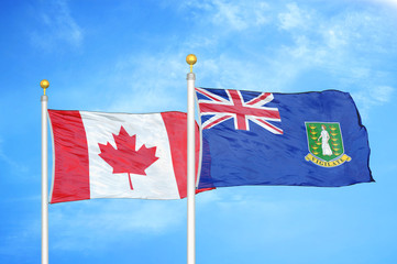 Canada and Virgin Islands British two flags on flagpoles and blue cloudy sky